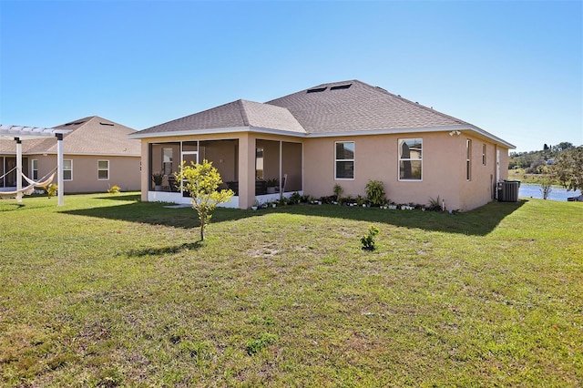 rear view of house featuring a lawn, cooling unit, and a sunroom