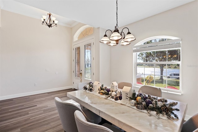 dining room with dark hardwood / wood-style floors, french doors, crown molding, and an inviting chandelier