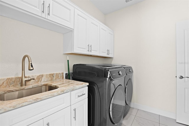 laundry room with washing machine and clothes dryer, sink, and cabinets