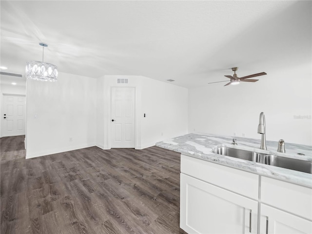 kitchen featuring white cabinets, hanging light fixtures, dark wood-type flooring, and sink