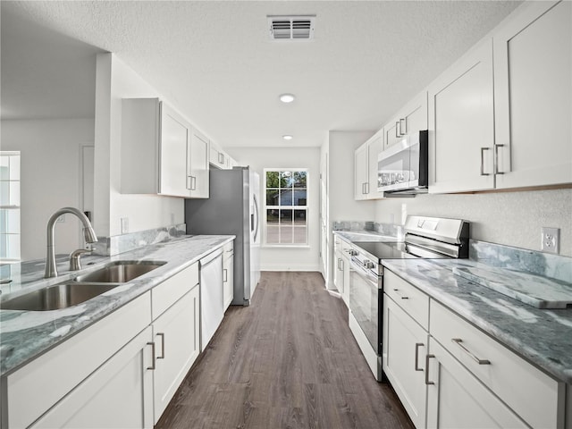 kitchen featuring dark hardwood / wood-style flooring, sink, white cabinetry, and stainless steel appliances