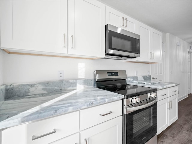 kitchen with white cabinets, dark hardwood / wood-style flooring, stainless steel appliances, and light stone countertops