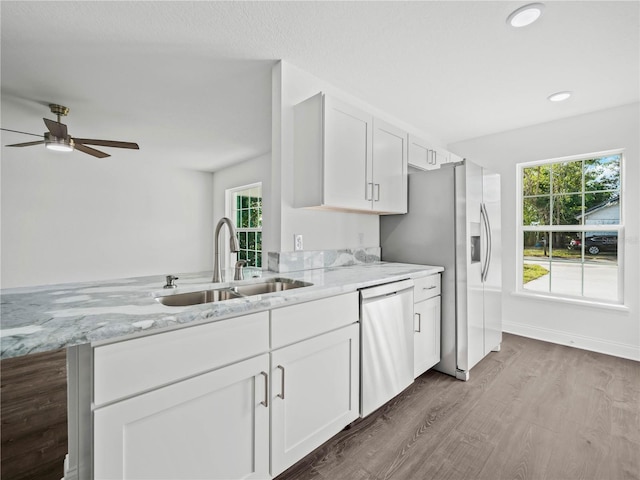 kitchen with kitchen peninsula, sink, white cabinets, and appliances with stainless steel finishes