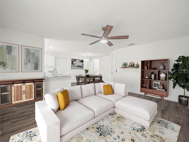 living room featuring ceiling fan, sink, dark wood-type flooring, and wine cooler