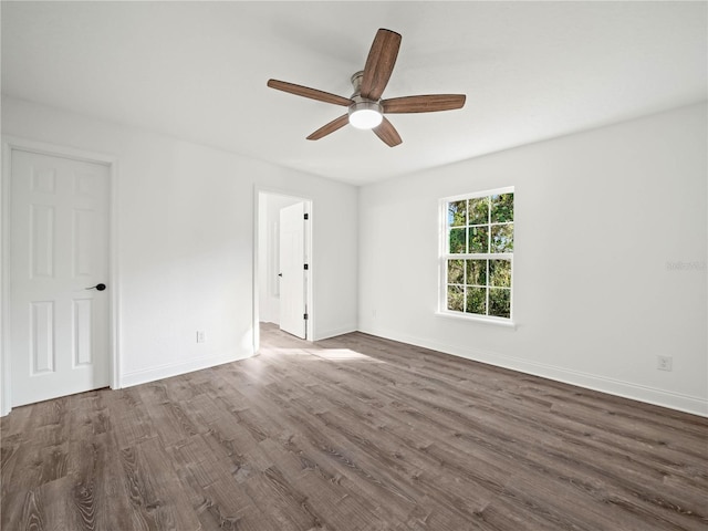 spare room with dark hardwood / wood-style floors and ceiling fan