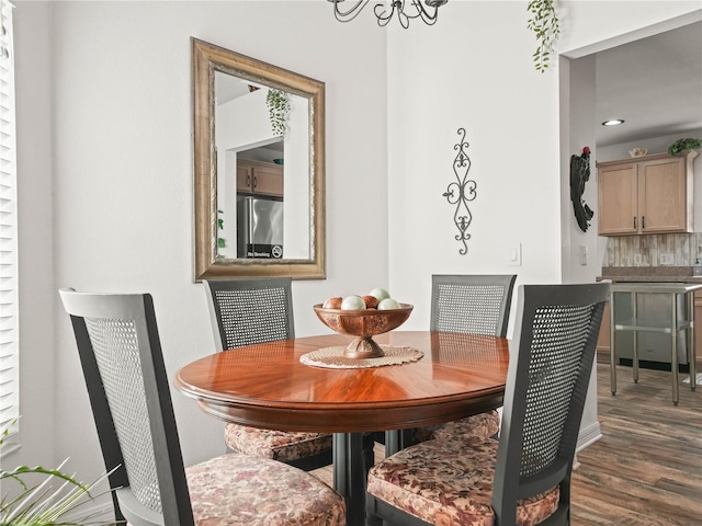 dining room with dark hardwood / wood-style floors and a notable chandelier