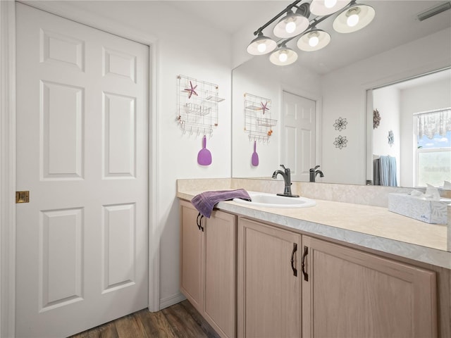 bathroom featuring hardwood / wood-style floors, vanity, and an inviting chandelier