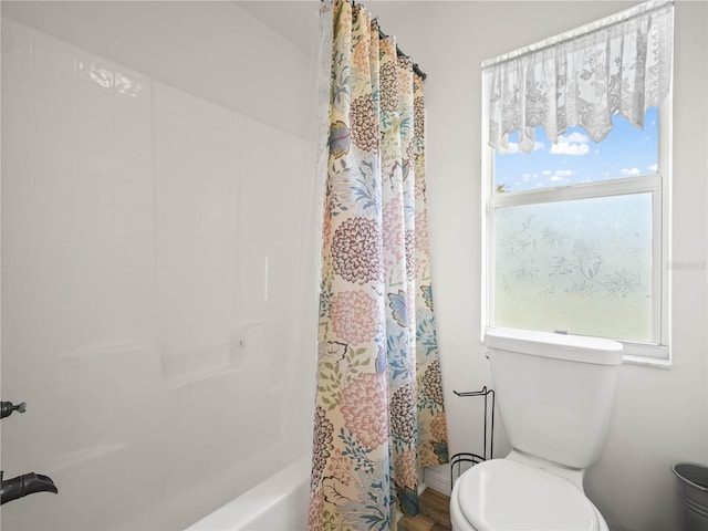 bathroom with hardwood / wood-style floors, toilet, plenty of natural light, and shower / bath combo