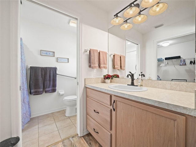 bathroom with tile patterned floors, vanity, a notable chandelier, and toilet