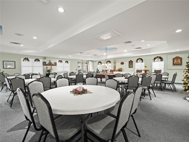 dining room featuring carpet flooring, a tray ceiling, and a healthy amount of sunlight