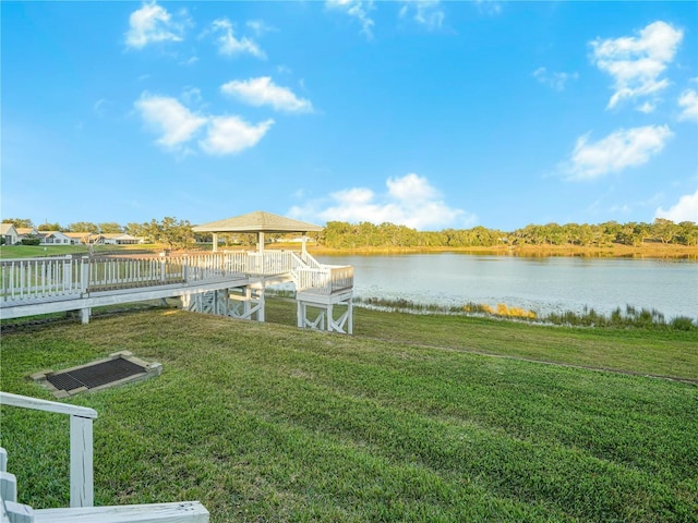 view of dock featuring a lawn and a water view