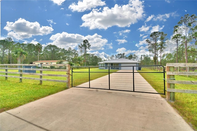 view of gate featuring a yard and a garage