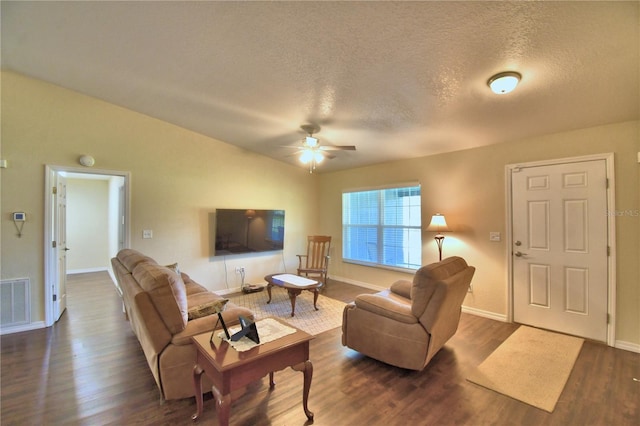 living room featuring a textured ceiling, ceiling fan, and dark wood-type flooring