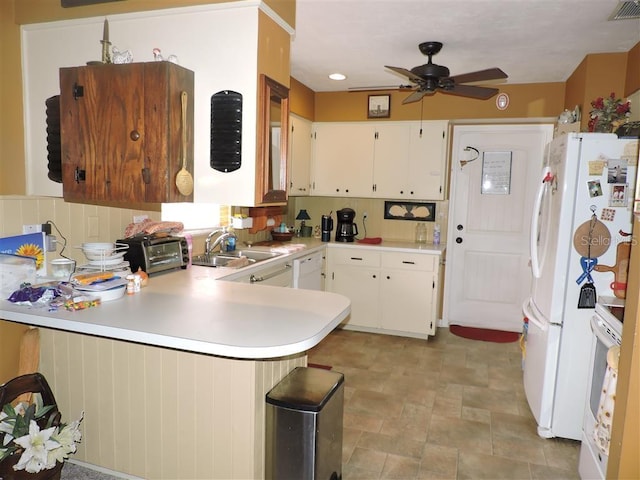 kitchen with white cabinets, kitchen peninsula, decorative backsplash, and sink