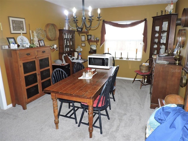 carpeted dining room featuring an inviting chandelier