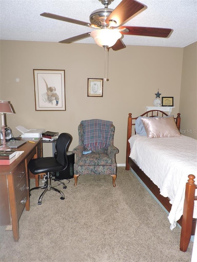 carpeted bedroom with ceiling fan and a textured ceiling