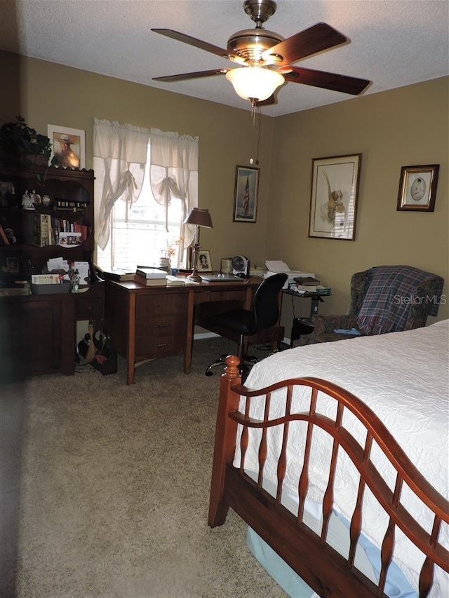 bedroom with a textured ceiling, carpet floors, and ceiling fan