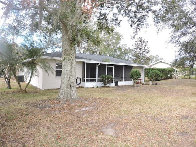 back of house featuring a sunroom and a yard