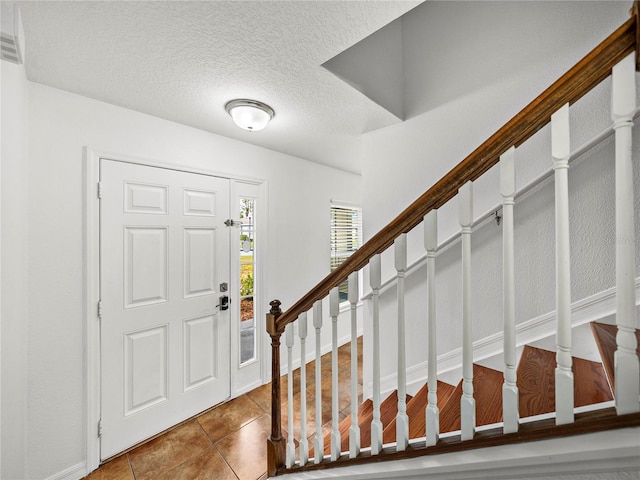 entrance foyer featuring tile patterned flooring and a textured ceiling