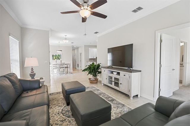 tiled living room with ceiling fan and ornamental molding