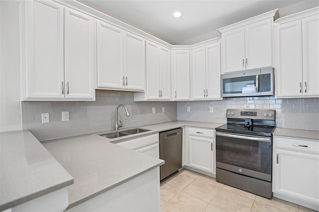 kitchen featuring sink, light tile patterned floors, backsplash, white cabinets, and appliances with stainless steel finishes