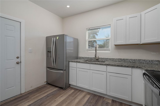 kitchen with white cabinets, stainless steel fridge with ice dispenser, and sink