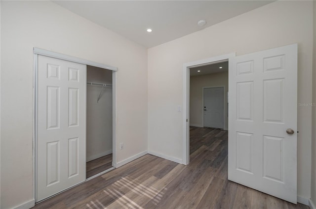 unfurnished bedroom featuring hardwood / wood-style floors and a closet