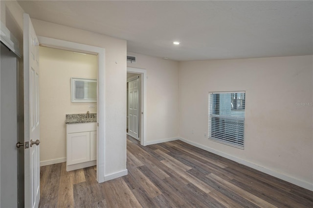 unfurnished bedroom featuring sink and dark hardwood / wood-style floors