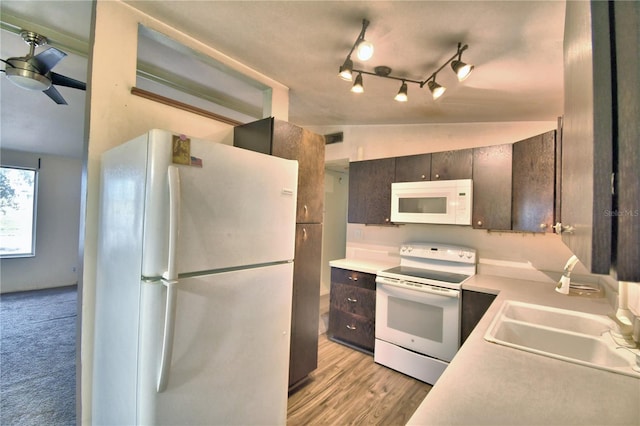 kitchen with lofted ceiling, ceiling fan, sink, white appliances, and dark brown cabinetry