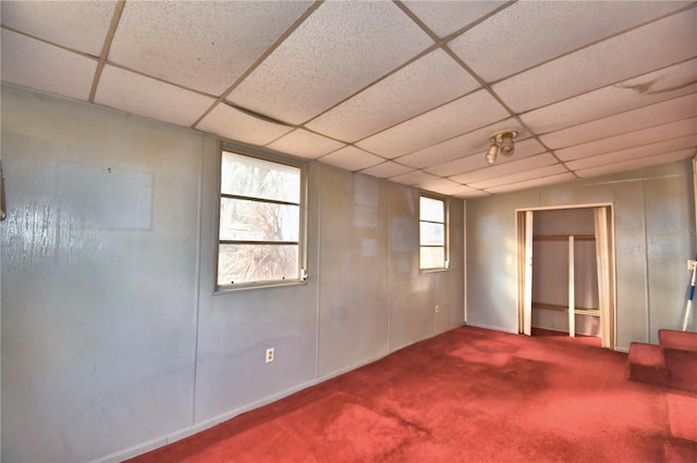 basement featuring carpet and a paneled ceiling