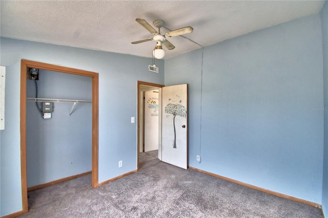 unfurnished bedroom with ceiling fan, a textured ceiling, a closet, and carpet flooring