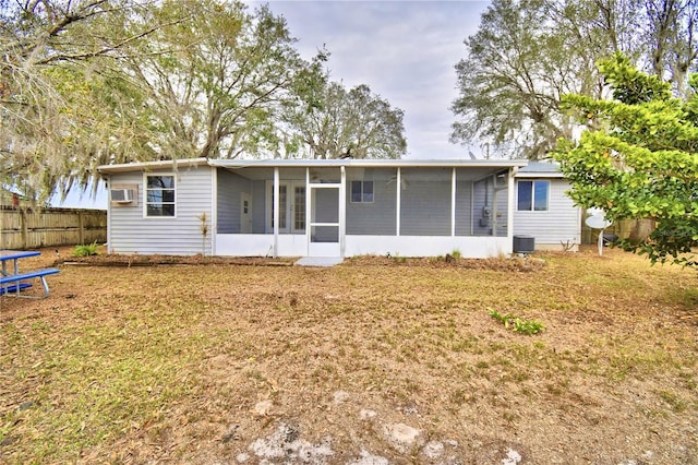 back of house featuring a sunroom, cooling unit, and a yard