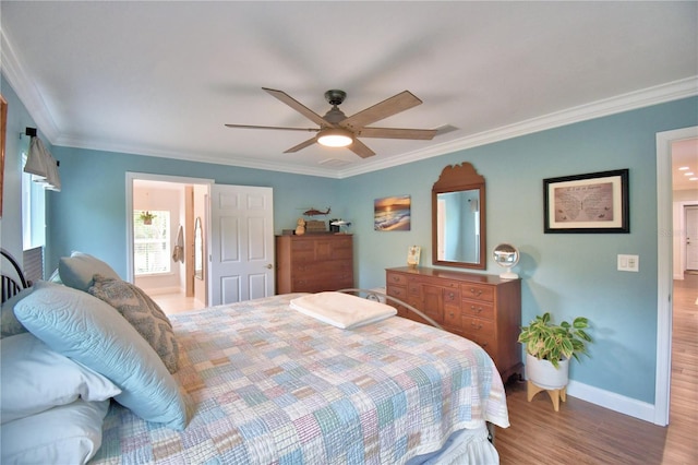 bedroom featuring a ceiling fan, baseboards, ornamental molding, and wood finished floors