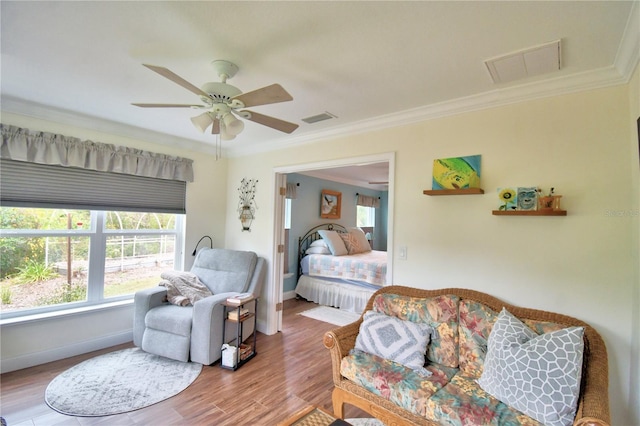 bedroom featuring visible vents, crown molding, and wood finished floors