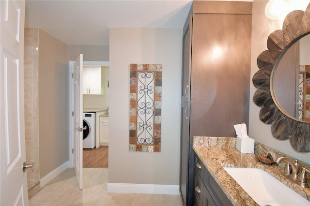 bathroom featuring washer / dryer, baseboards, and vanity