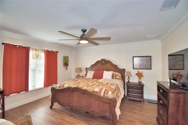 bedroom featuring dark wood-type flooring, visible vents, crown molding, and baseboards