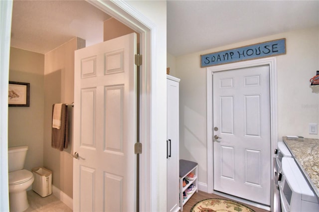 bathroom featuring toilet, baseboards, and vanity