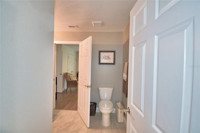 ensuite bathroom featuring toilet, tile patterned flooring, visible vents, and ensuite bathroom