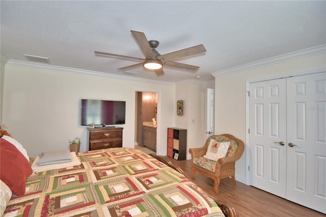 bedroom with wood finished floors, visible vents, a ceiling fan, ornamental molding, and a closet