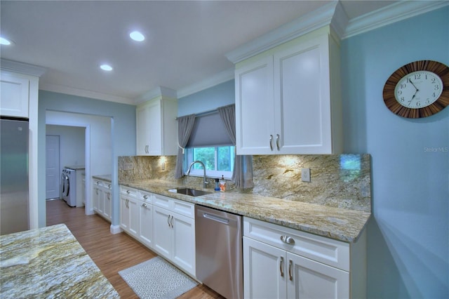 112 Reedy Creek Dr, Frostproof, FL 33843 - kitchen with appliances with stainless steel finishes, independent washer and dryer, ornamental molding, tasteful backsplash, and light wood-style flooring