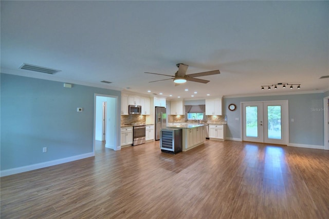112 Reedy Creek Dr, Frostproof, FL 33843 - kitchen with open floor plan, appliances with stainless steel finishes, wine cooler, a kitchen island, and tasteful backsplash