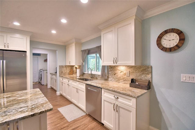 112 Reedy Creek Dr, Frostproof, FL 33843 - kitchen with washing machine and clothes dryer, appliances with stainless steel finishes, ornamental molding, decorative backsplash, and light wood-style flooring