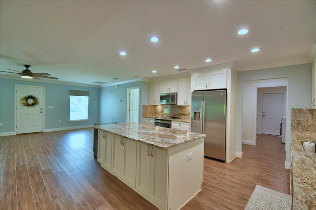 112 Reedy Creek Dr, Frostproof, FL 33843 - kitchen with appliances with stainless steel finishes, ornamental molding, a center island, light wood-style floors, and a ceiling fan