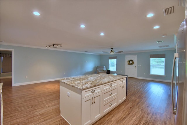 112 Reedy Creek Dr, Frostproof, FL 33843 - kitchen featuring open floor plan, ornamental molding, freestanding refrigerator, ceiling fan, and white cabinets