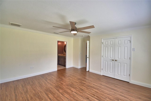 112 Reedy Creek Dr, Frostproof, FL 33843 - unfurnished bedroom with wood finished floors, crown molding, a closet, ceiling fan, and ensuite bathroom