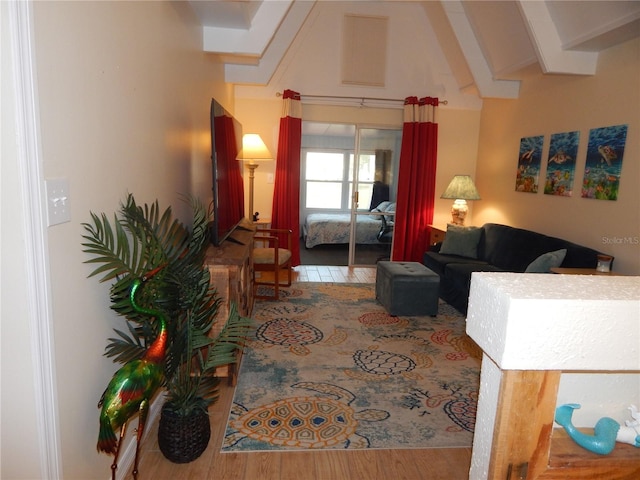 living room with hardwood / wood-style floors and vaulted ceiling with beams