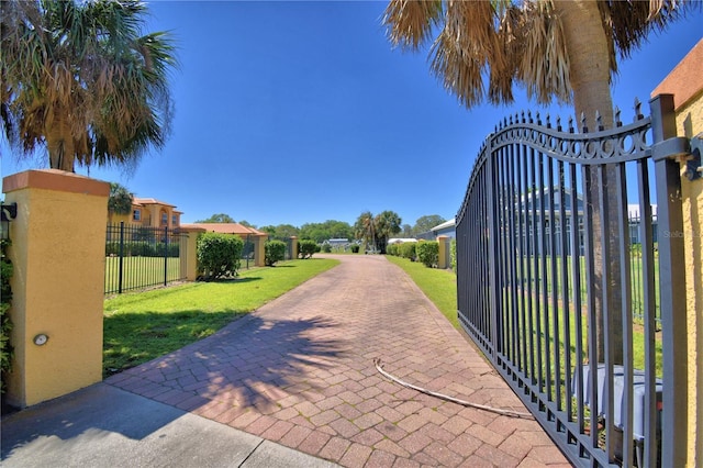 view of gate featuring a yard and fence