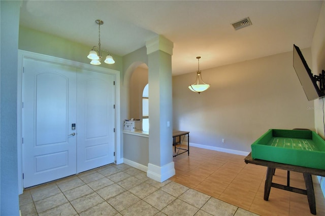 foyer with light tile patterned floors, visible vents, baseboards, and arched walkways