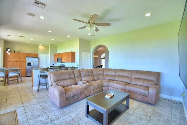 living room with light tile patterned floors, a ceiling fan, visible vents, recessed lighting, and arched walkways