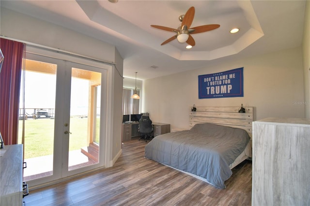 bedroom featuring wood finished floors, recessed lighting, access to exterior, french doors, and a raised ceiling